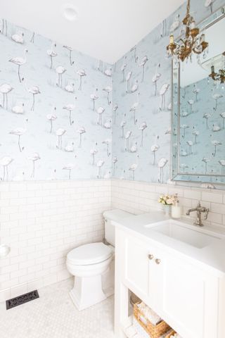 bathroom with metro tiles halfway up the wall and blue flamingo wallpaper