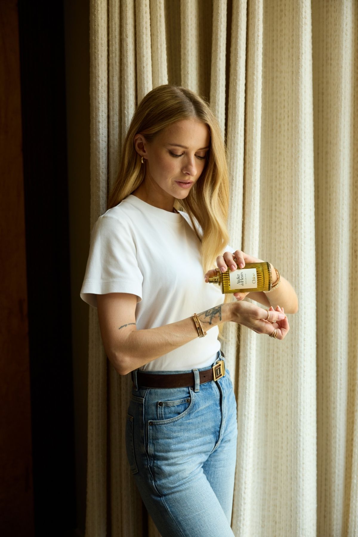 Victoria Magrath spraying a bottle of Chloé Atelier des Fleurs Sous les Pins