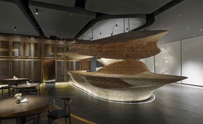 Raw restaurant with undulating wood-hewn sculptures that delineate its different areas