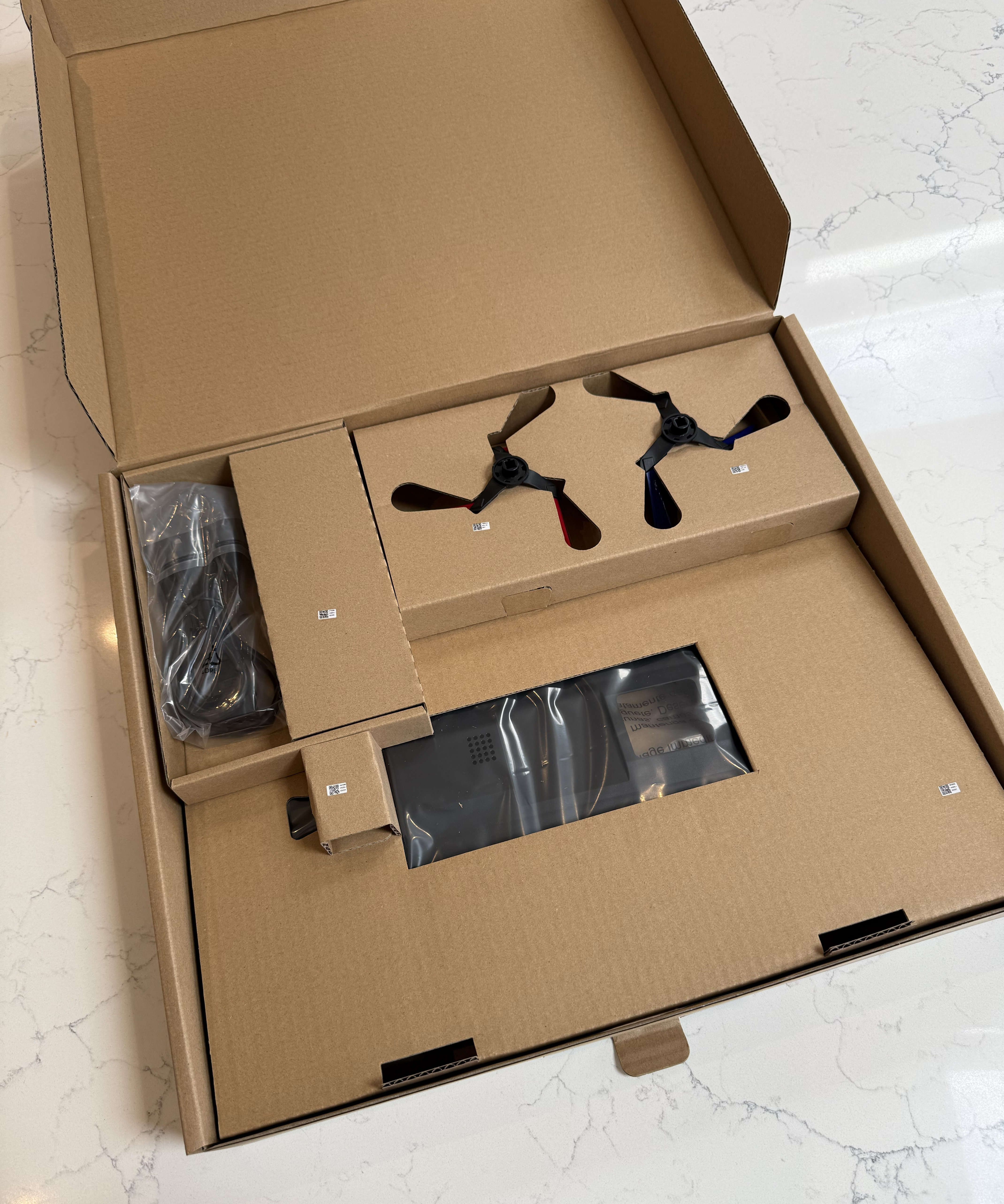 Dyson Spot+Scrub Ai accessories and side brushes packed inside the cardboard inner tray