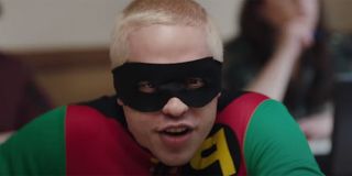 Pete Davidson dressed as Eminem dressed up as Robin in a reference to the Without Me music video while sitting in a chair inside a classroom.