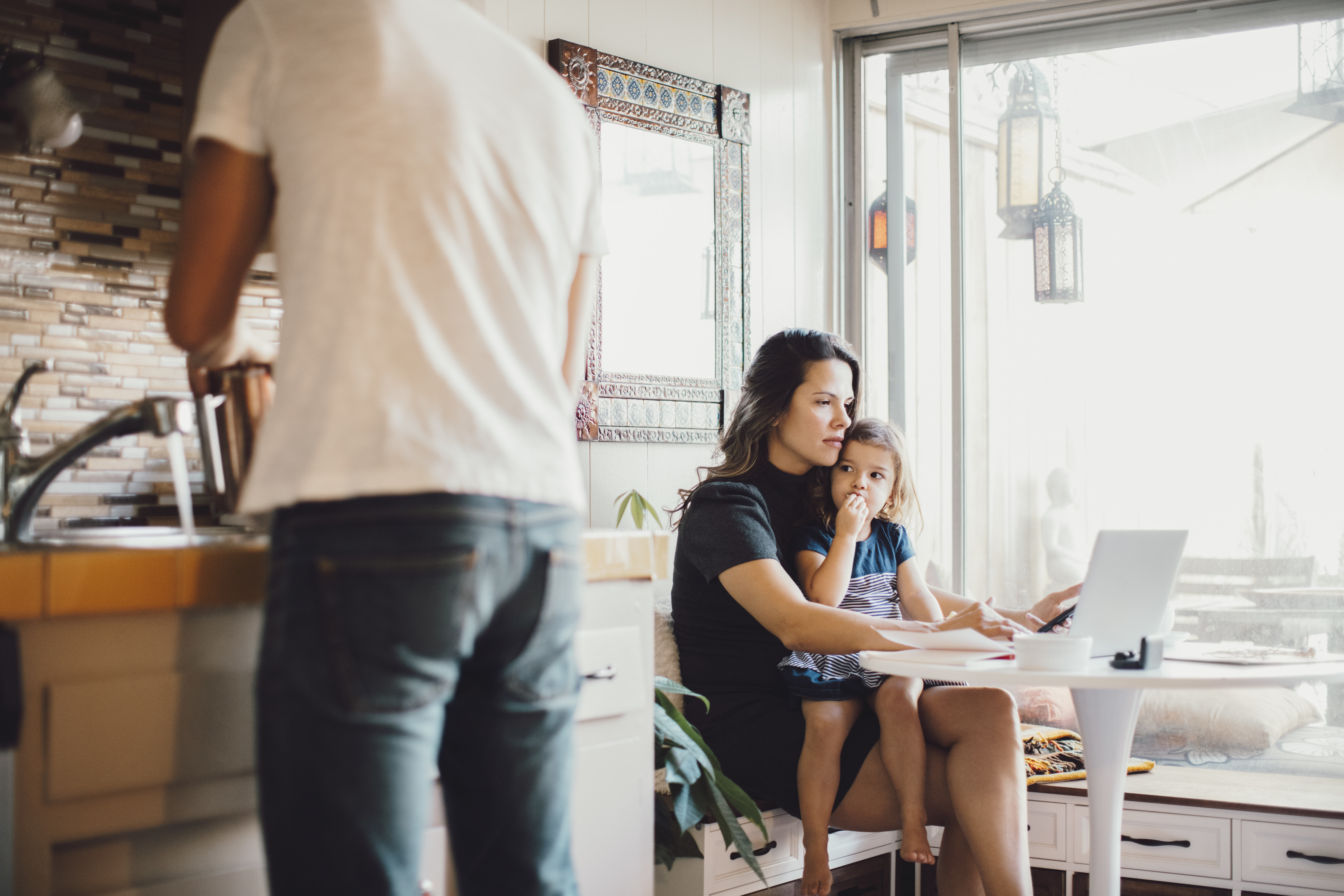Mother looking at laptop with child on her lap