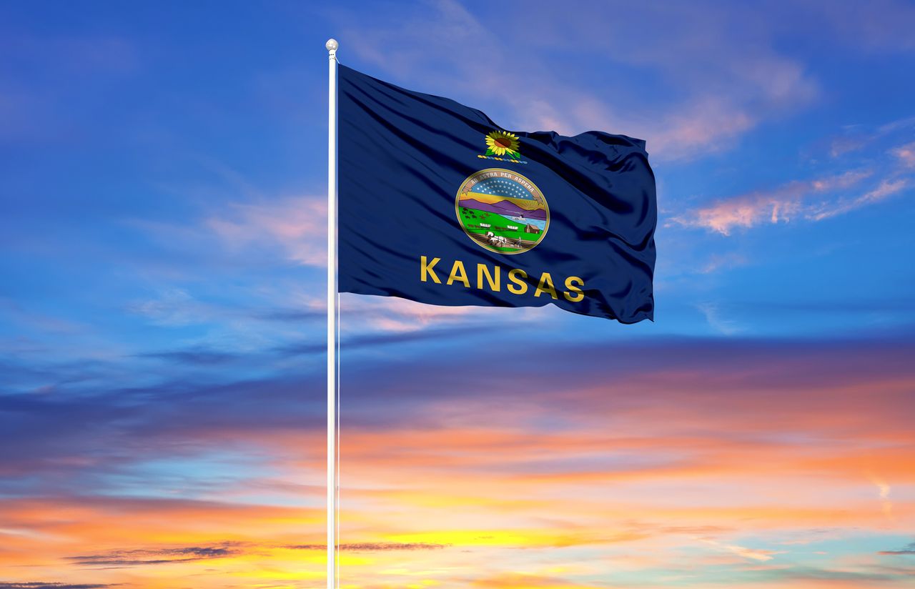 Kansas flag on flagpole and blue sky