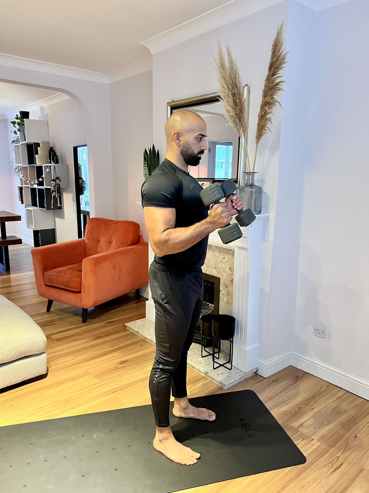 Personal trainer Ali Malik demonstrating the dumbbell hammer curl