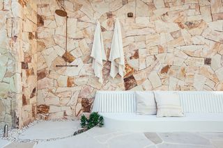 An outdoor shower with stone finish