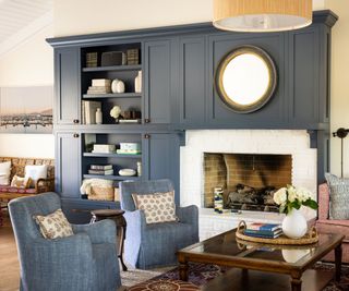 living room with blue armchairs and fireplace surround and sofa with patterned upholstery