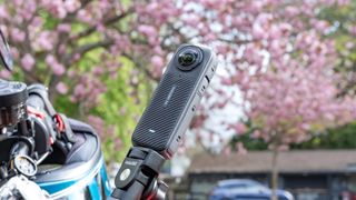 A photo of the Insta360 X4 mounted on motorcycle handlebars, tilted and with the frontal ridges pattern showing.