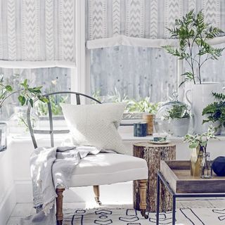 living room with with chair cushion plants and white curtains