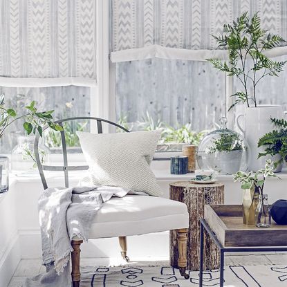 living room with with chair cushion plants and white curtains 