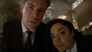 Chris Hemsworth and Tessa Thompson staring together at an object in Men In Black International.