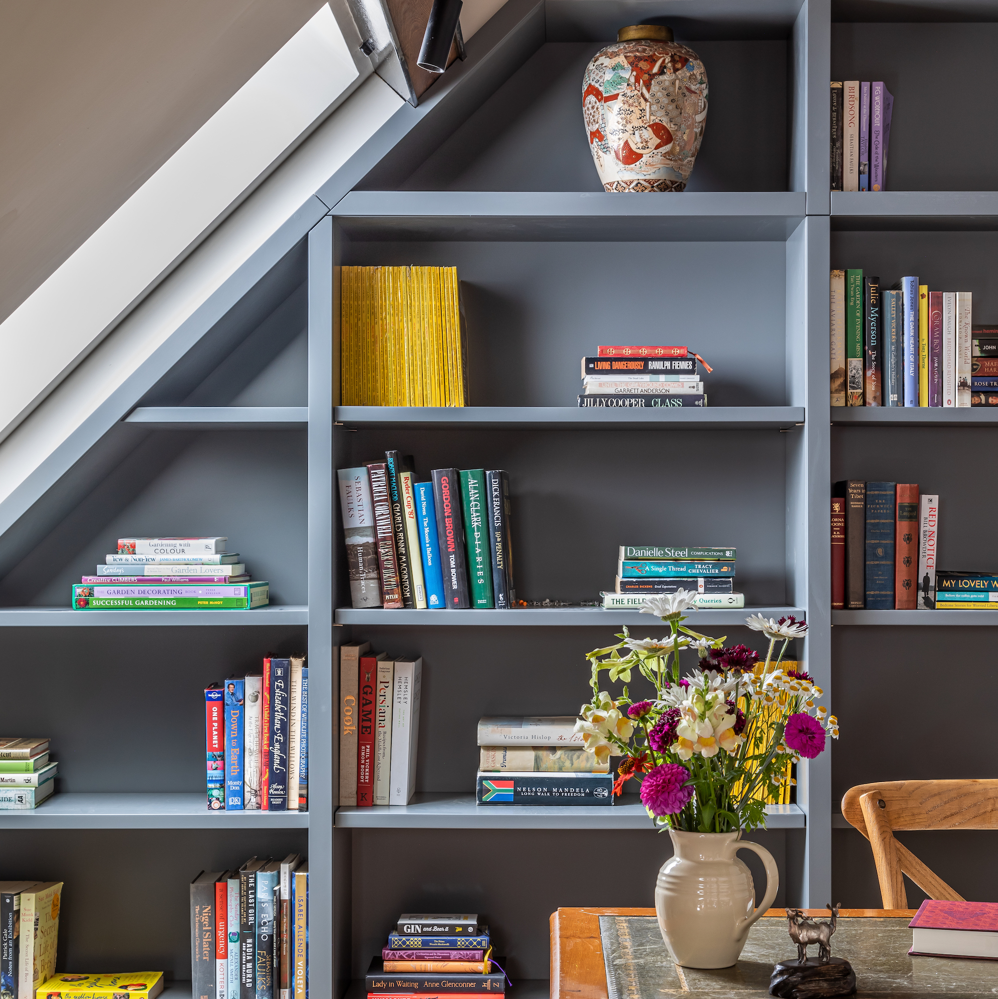 fitted bookshelves painted in grey paint with dormer window to side
