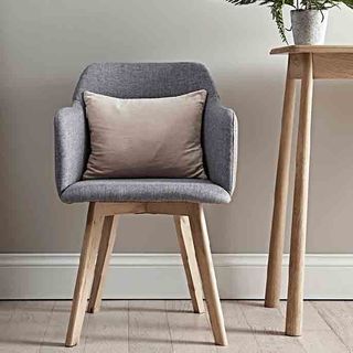 Cox & Cox grey cotton Upholstered Armchair with wooden legs next to wooden tables