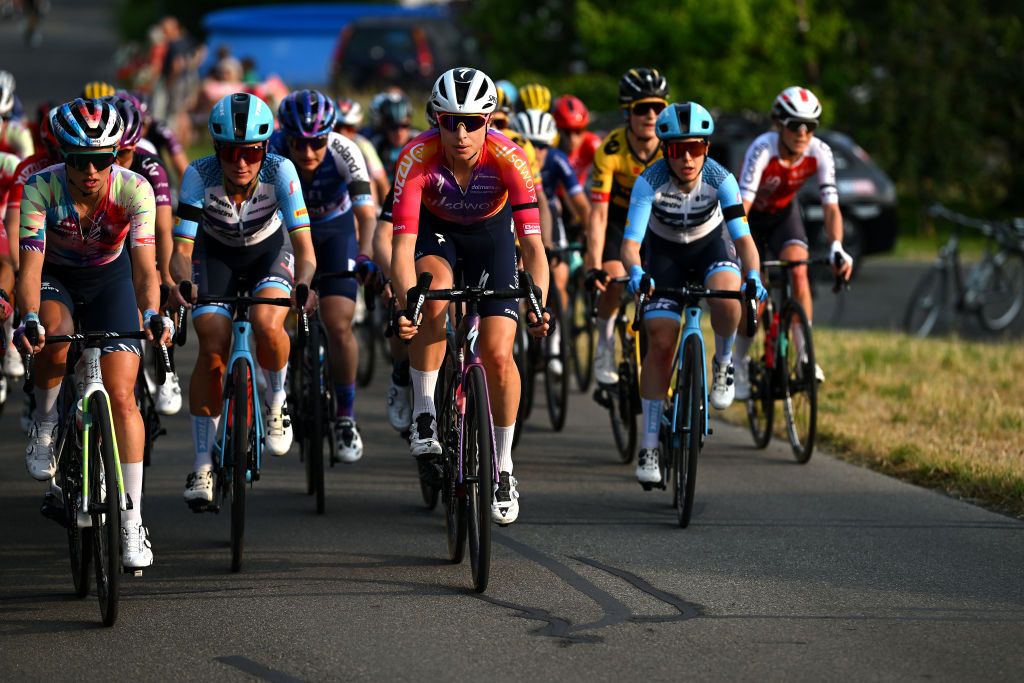 Riders in the peloton wear a black ribbon in memory of Gino Mäder prior to start of the Tour de Suisse Women 2023 