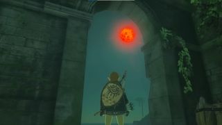 Link in Zelda: Tears of the Kingdom steht in den Ruinen und schaut zum Blutmond hinauf.