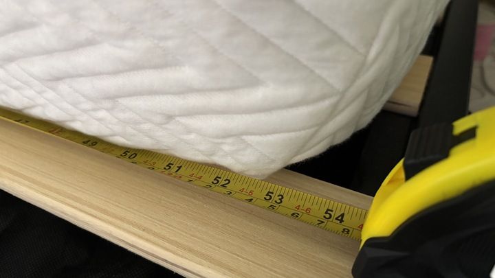 A tape measures the width of the Legend Hybrid Mattress