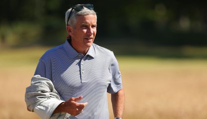 Monahan walks the fairway holding a jacket