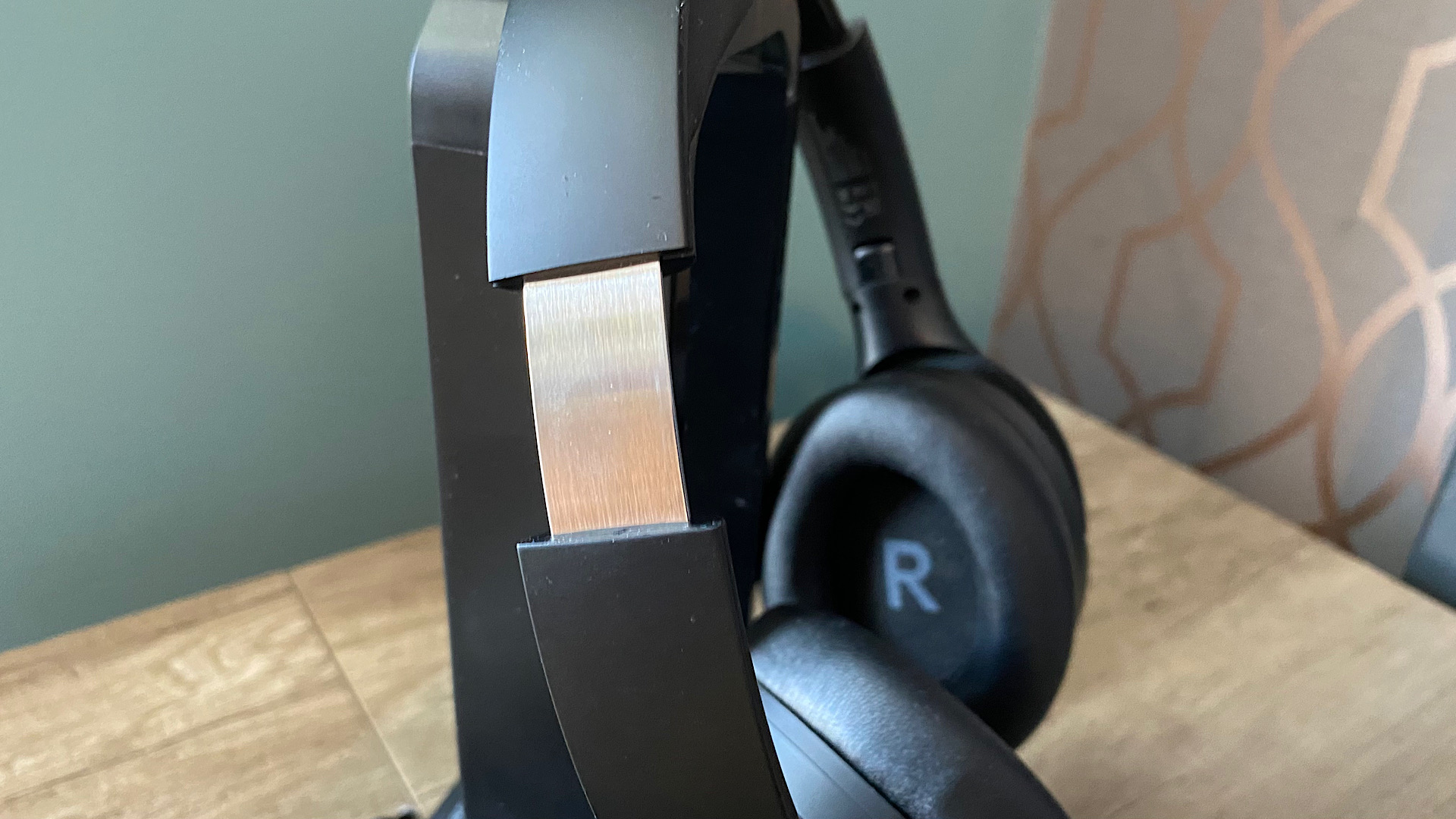 Happy Plugs Play Pro over-ear headphones on a wooden surface