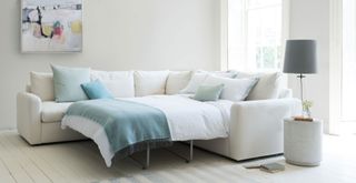 white living room with white sofa that turns into a double bed to highlight key sofa trends 2023