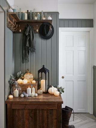 Fall display in hallway with pumpkin lights, a lantern and candles