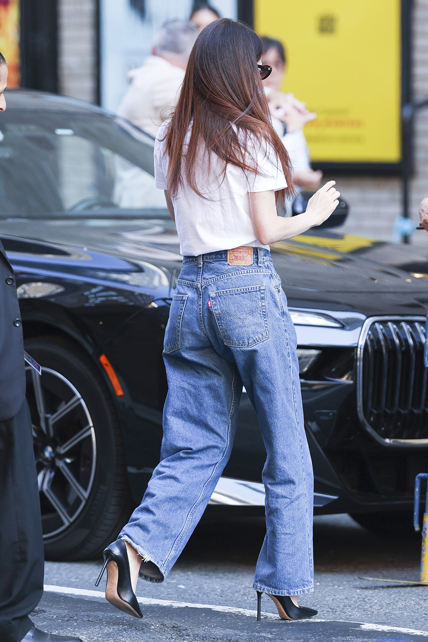 Molly Gordon wearing a white Stephen Colbert T-shirt, jeans, and black pointed-toe pumps in NYC