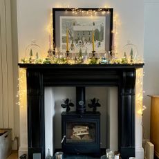 fireplace with candles and lights on top of the mantle
