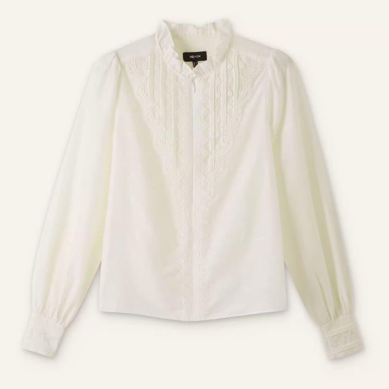 A cutout of a lace trim blouse against a pale background by Briitsh clothing brand ME+EM