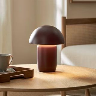 Maroon mushroom lamp on a wooden side table in a beige room