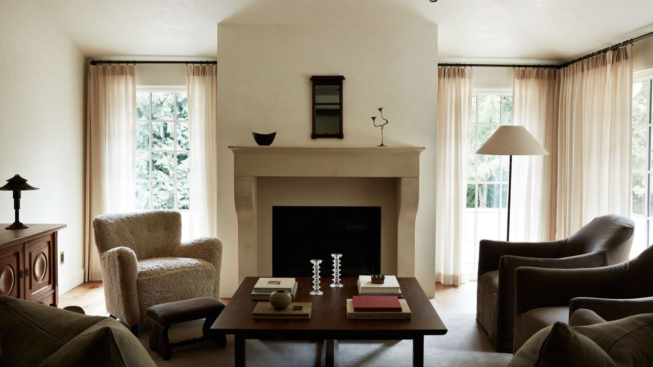 Neutral sunlut living room area featuring a shearling accent chair, reclaimed wood furniture, and collected objects.