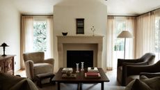Neutral sunlut living room area featuring a shearling accent chair, reclaimed wood furniture, and collected objects.