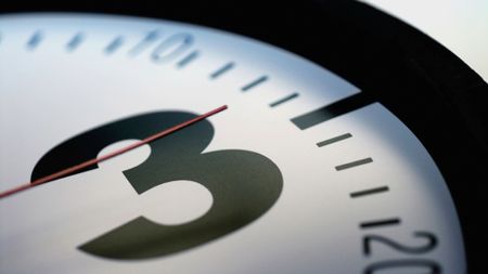 Close-up of the second hand of a clock on number three 