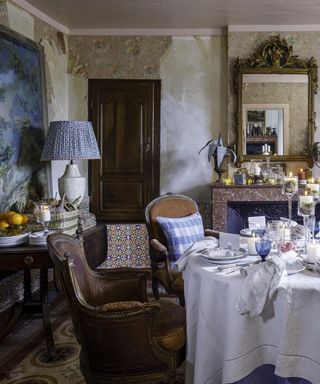 french country dining room with antique furnishings, a lavish tablescape and peeling wallpaper for a rustic feel