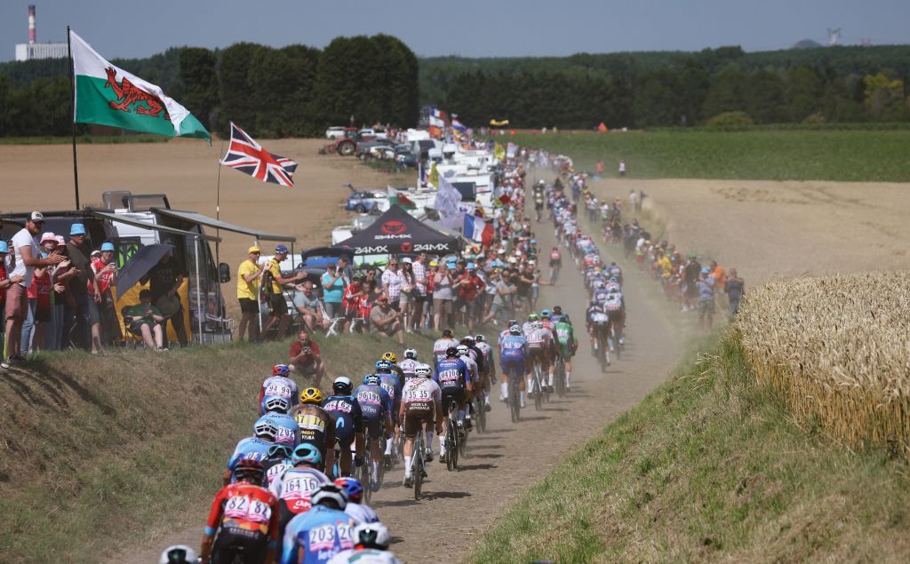 The pack of riders cycles across a cobblestone sector during the 5th stage of the 109th edition of the Tour de France cycling race 1537 km between Lille and Arenberg Porte du Hainaut in northern France on July 6 2022 Photo by Thomas SAMSON AFP Photo by THOMAS SAMSONAFP via Getty Images