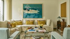 a neutral london living room with a large cream sectional and a blue and yellow color palette