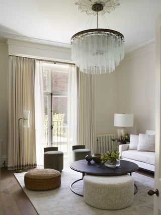 Neutral living room with sofa, coffee table and ottomans and chandelier