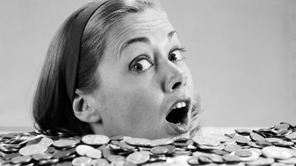 UNITED STATES - CIRCA 1960s: Woman pulling funny face, up to her neck in coins.