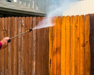 Pressure washing a wooden fence