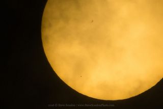 Tiny dot of Mercury in lower left of sun's orange orb