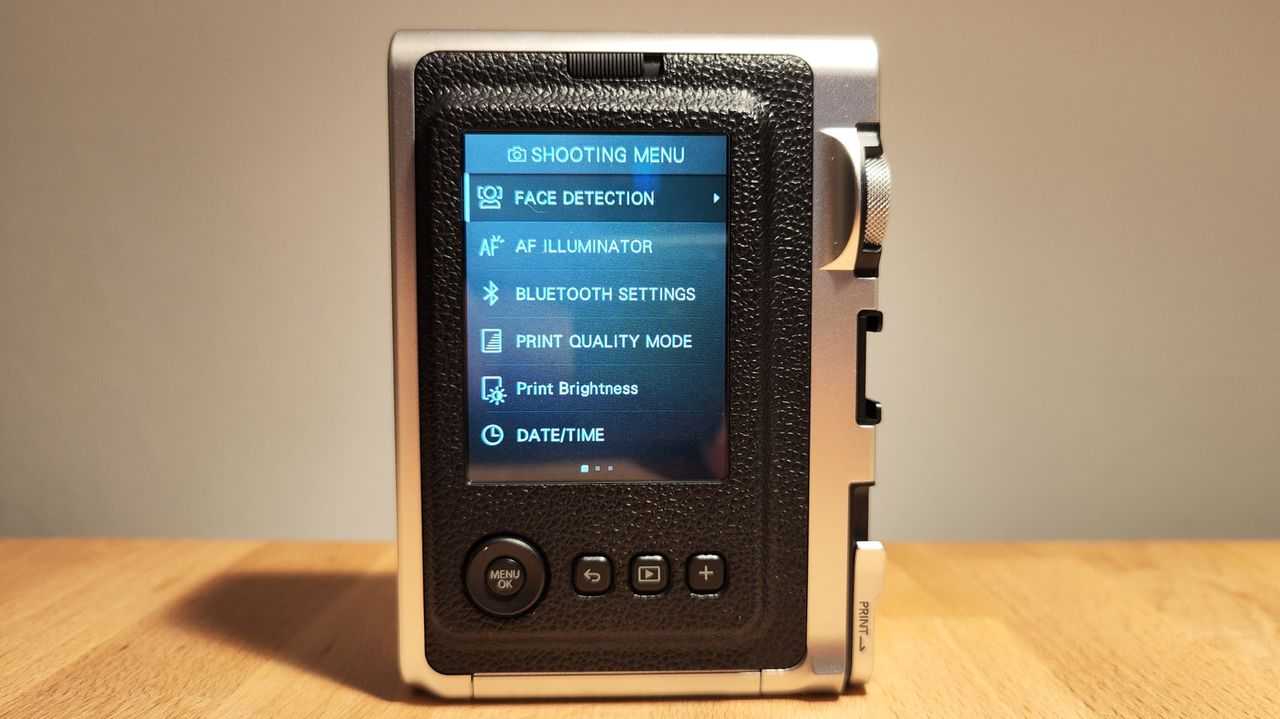 The Fujifilm Instax Mini Evo on a wooden table