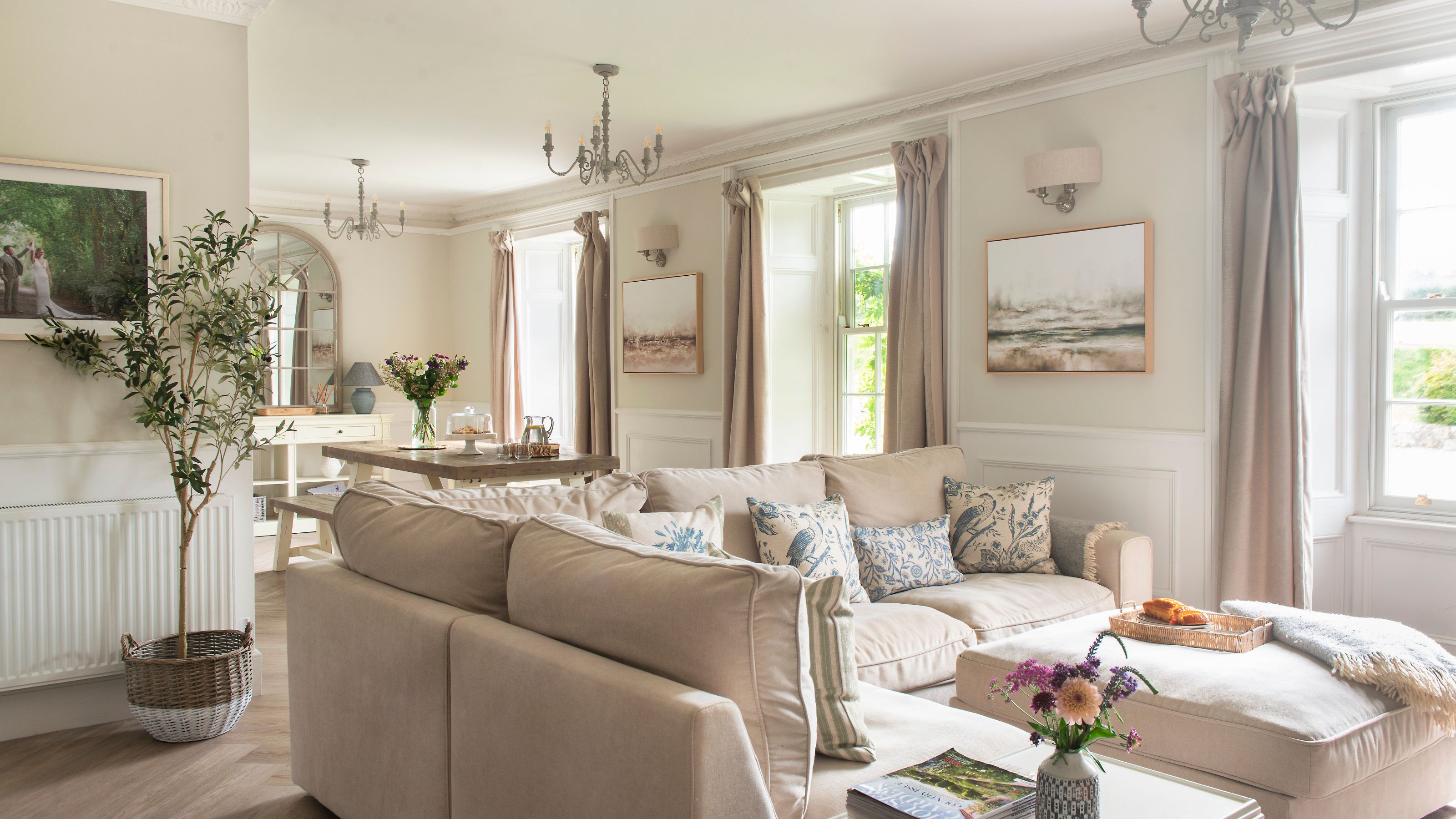 Open plan living room and dining room with neutral decor and high windows