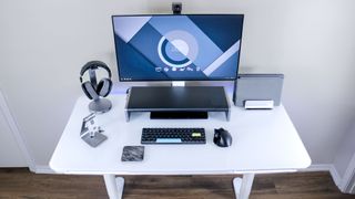 An overhead view of the LiftSync Clear Plus standing desk with a monitor, laptop and other accessories