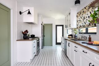 a small white kitchen with sage green doors