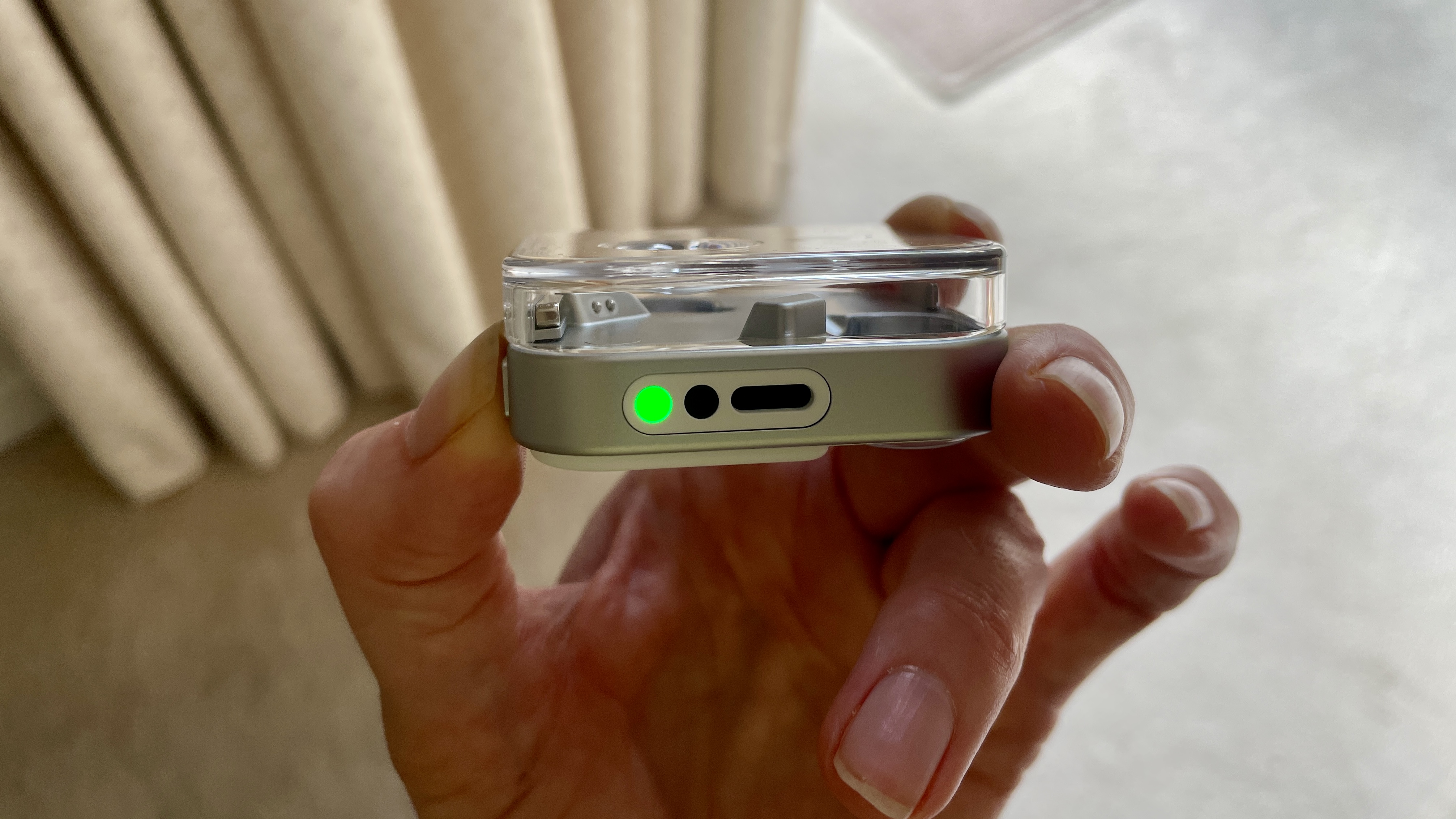 Nothing Ear (3)'s case, with the Super Mic green light illuminated to show the mic is working