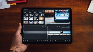 Man holding iPad with video editing software on screen