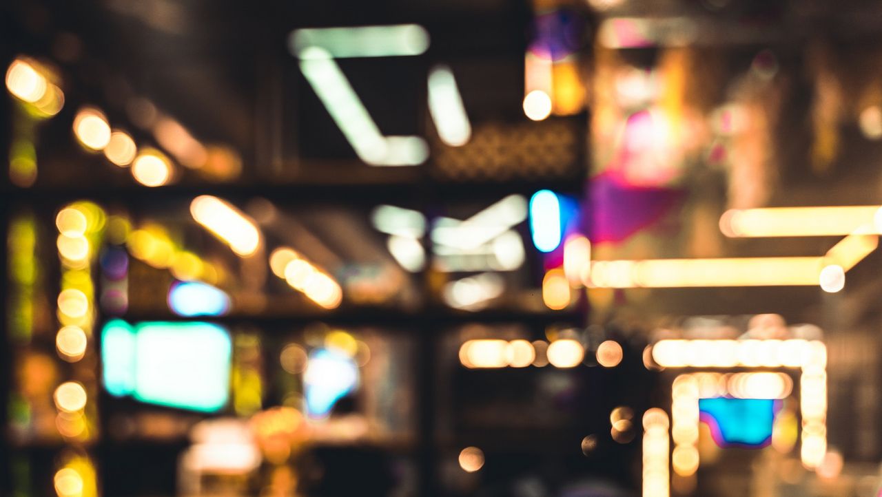 An abstract, blurred lights image of the interior of a casino.