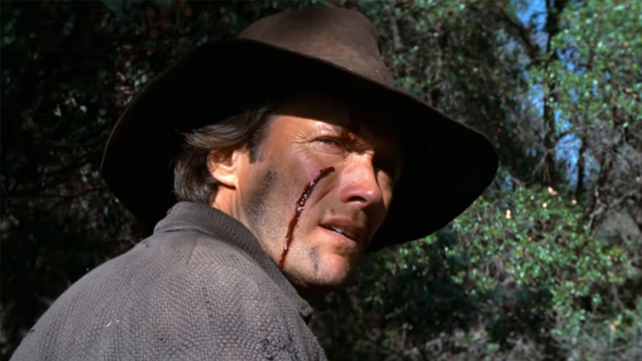 Clint Eastwood looking over his right shoulder with blood on his face