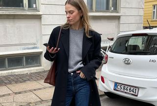 Woman in gray sweater and black coat.