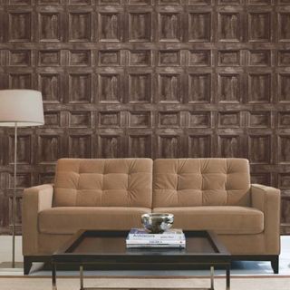 Brownish couch in front of wooden panel effect wall with coffee table and lamp