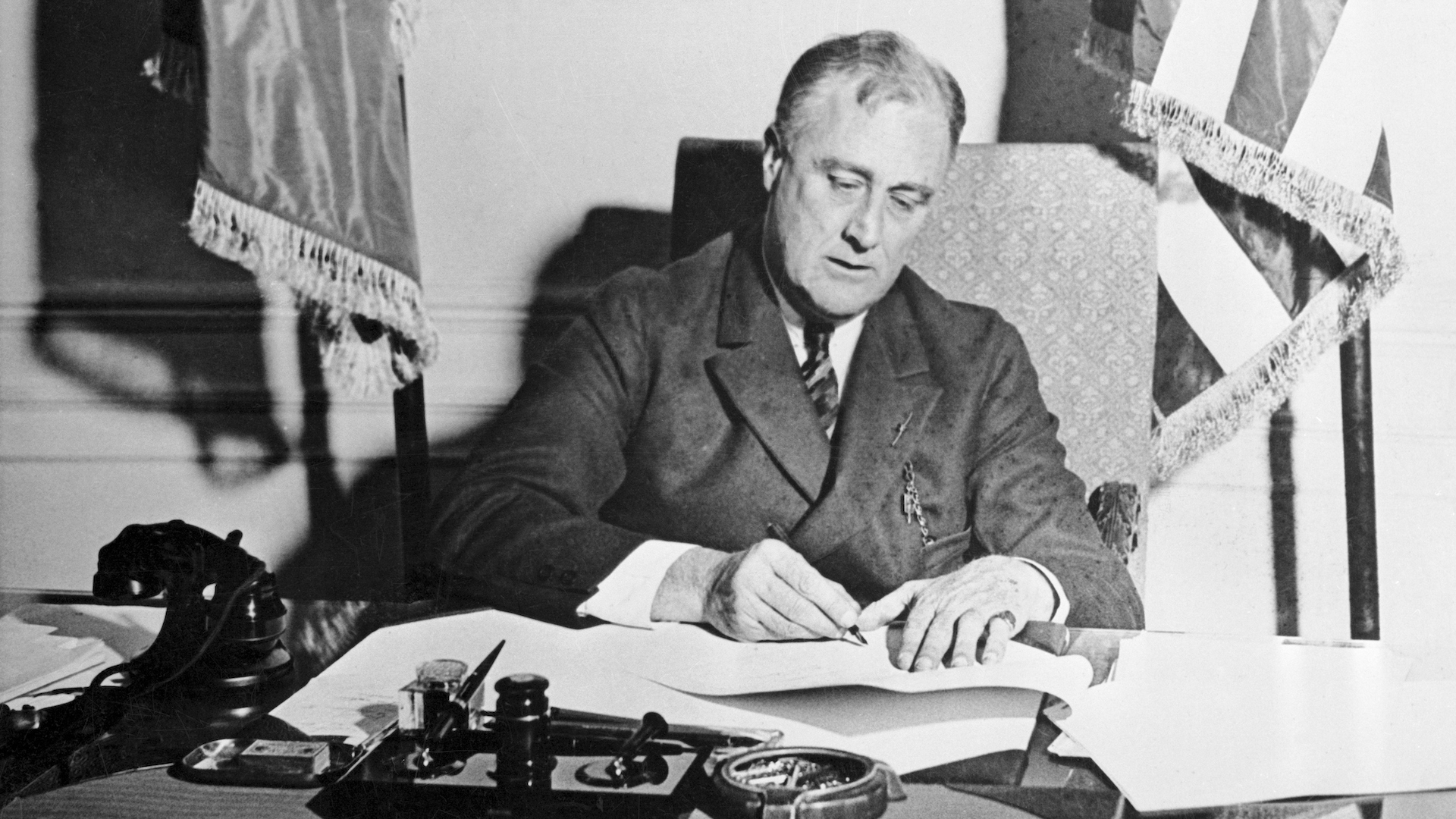 FDR signing a paper on his desk