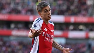 Leandro Trossard gesticulates on the pitch in his red and white Arsenal strip.