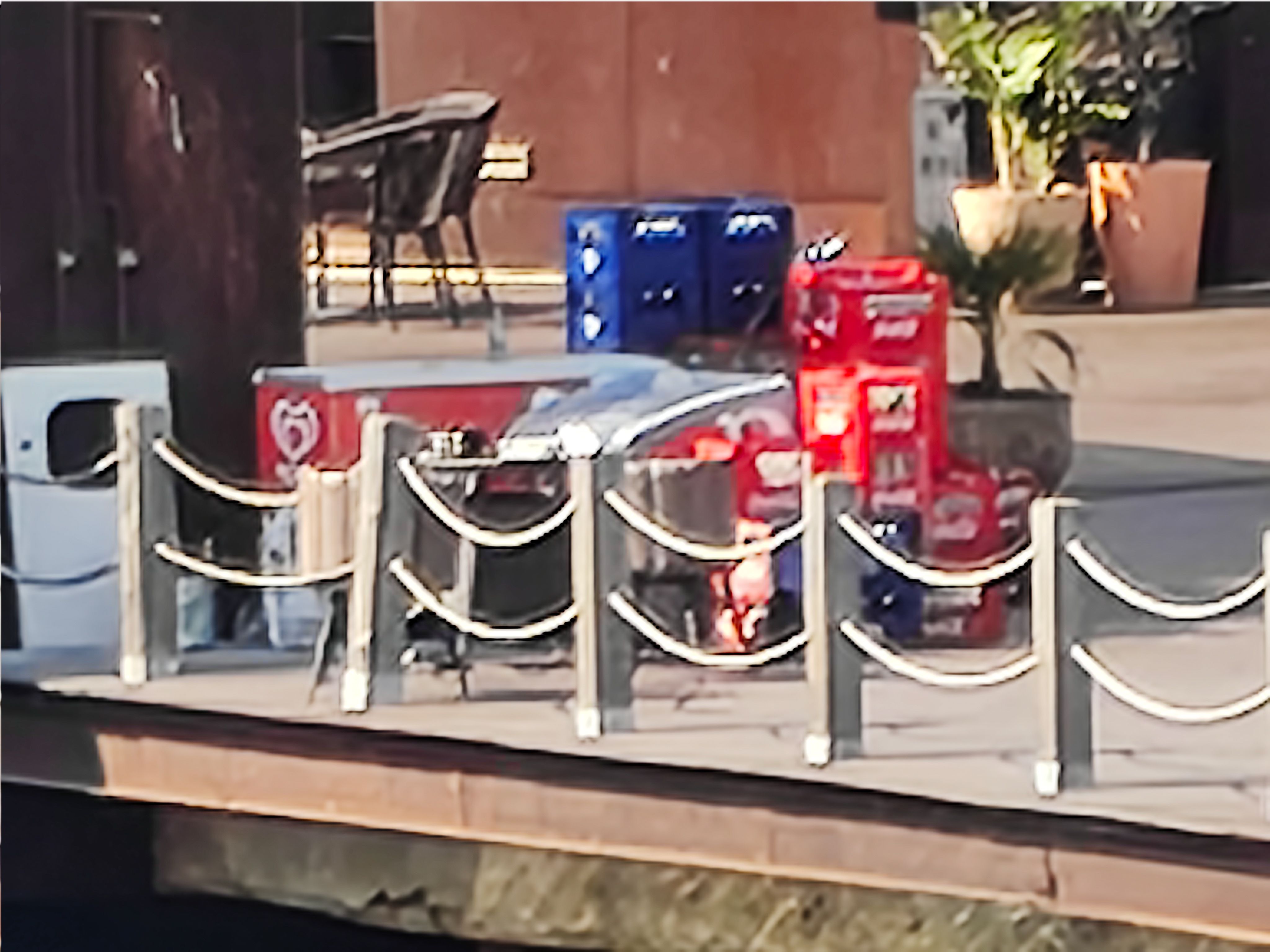 Highly zoomed view of a quay with stacked beverage crates and barriers near the marina, captured with the Nothing Phone (4a).
